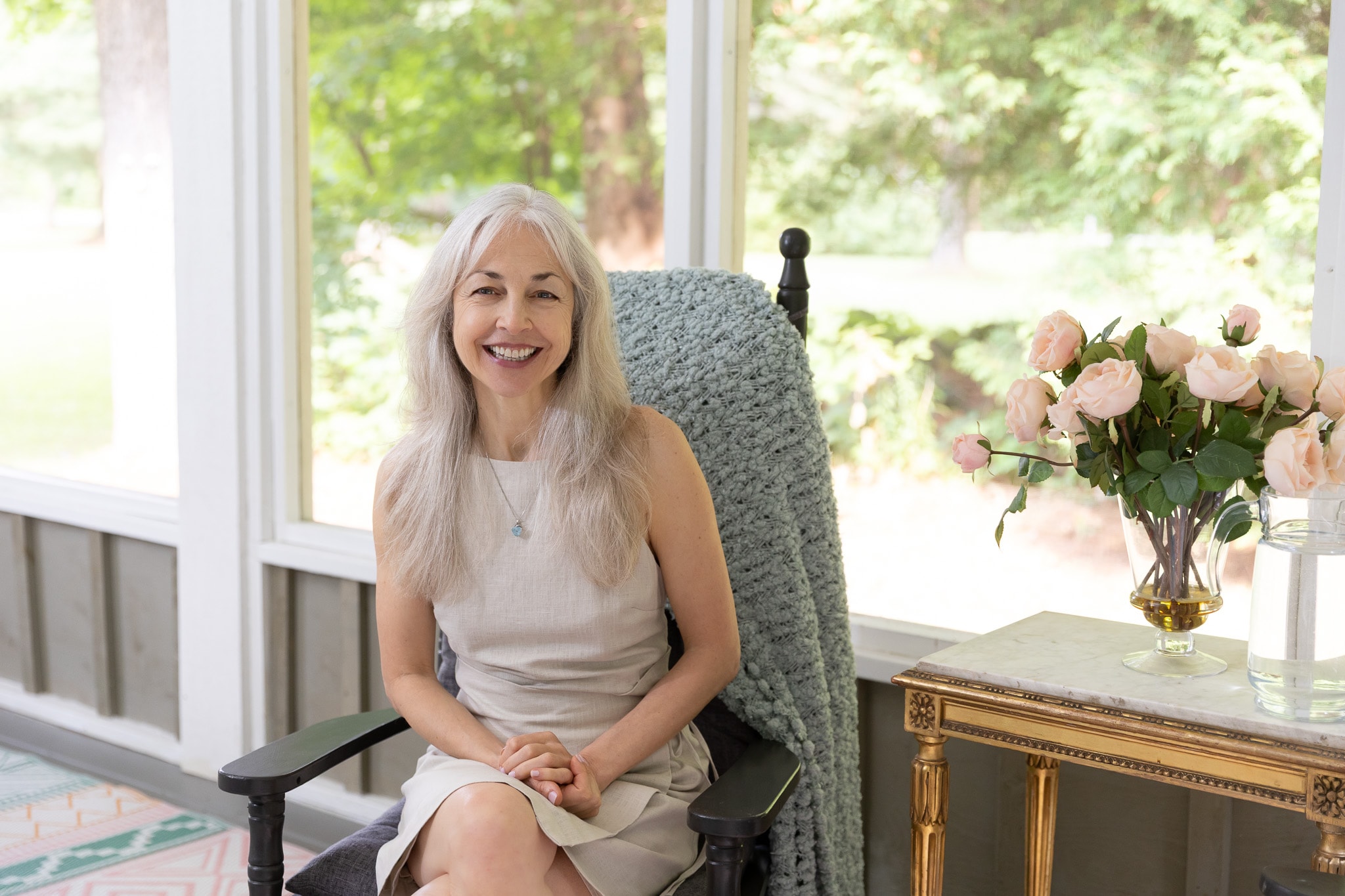 Lori seated and smiling in the sunroom
